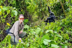 female_tourist_next_to_young_mountain_gorilla